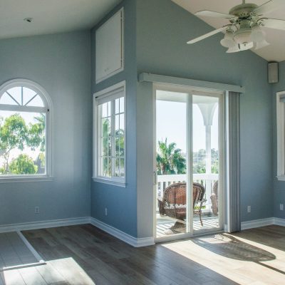 A trendy modern interior of a living room with blue walls and white windows